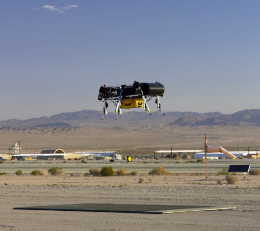 C200 flying testbed hovering over a desert test range